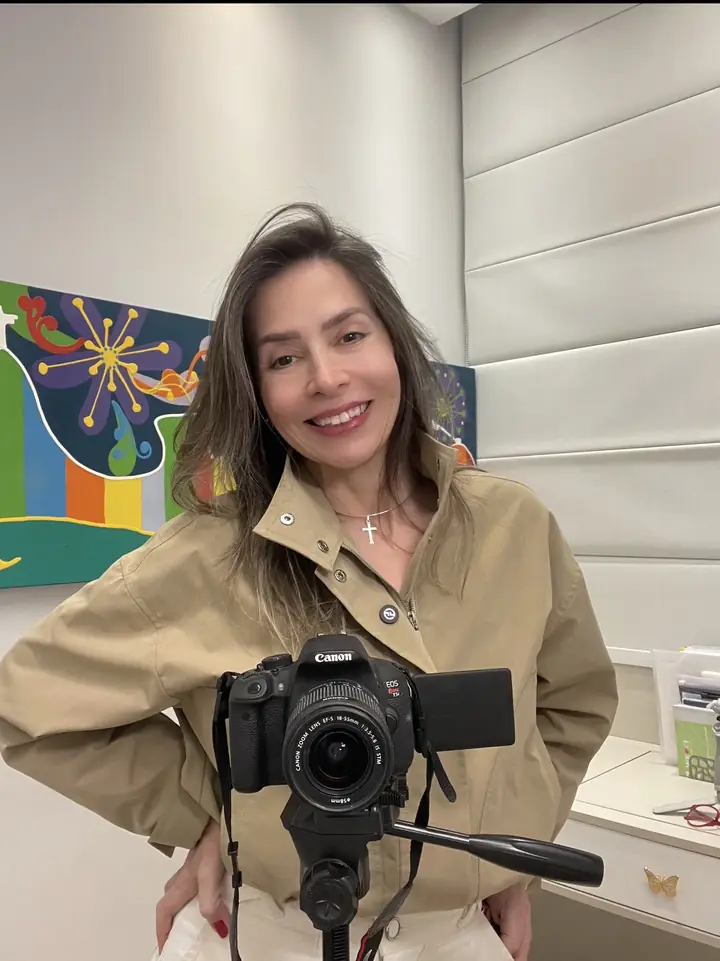 Lu Rivoli nos bastidores, atrás de uma câmera no tripé